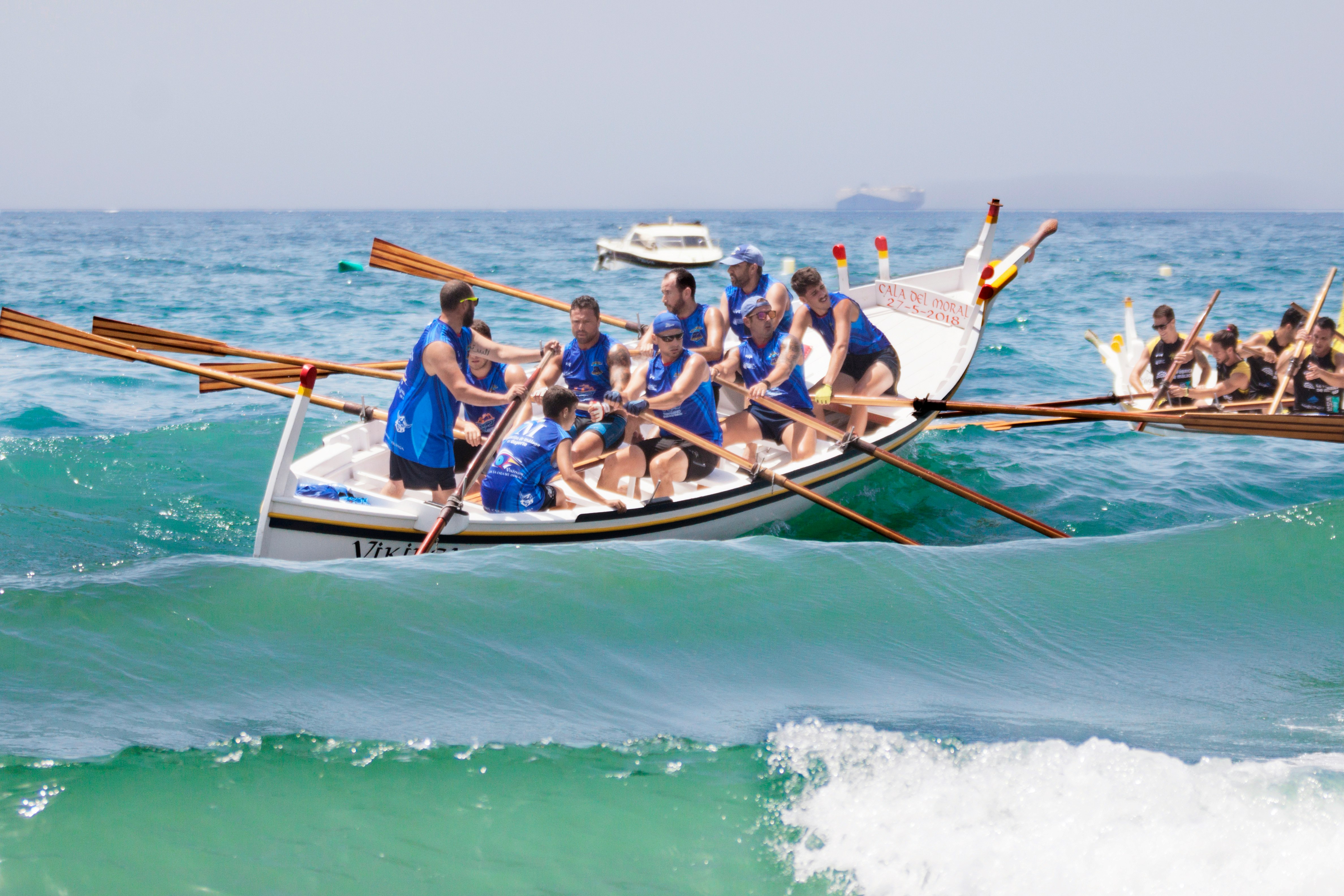 people riding on blue and white boat on sea during daytime